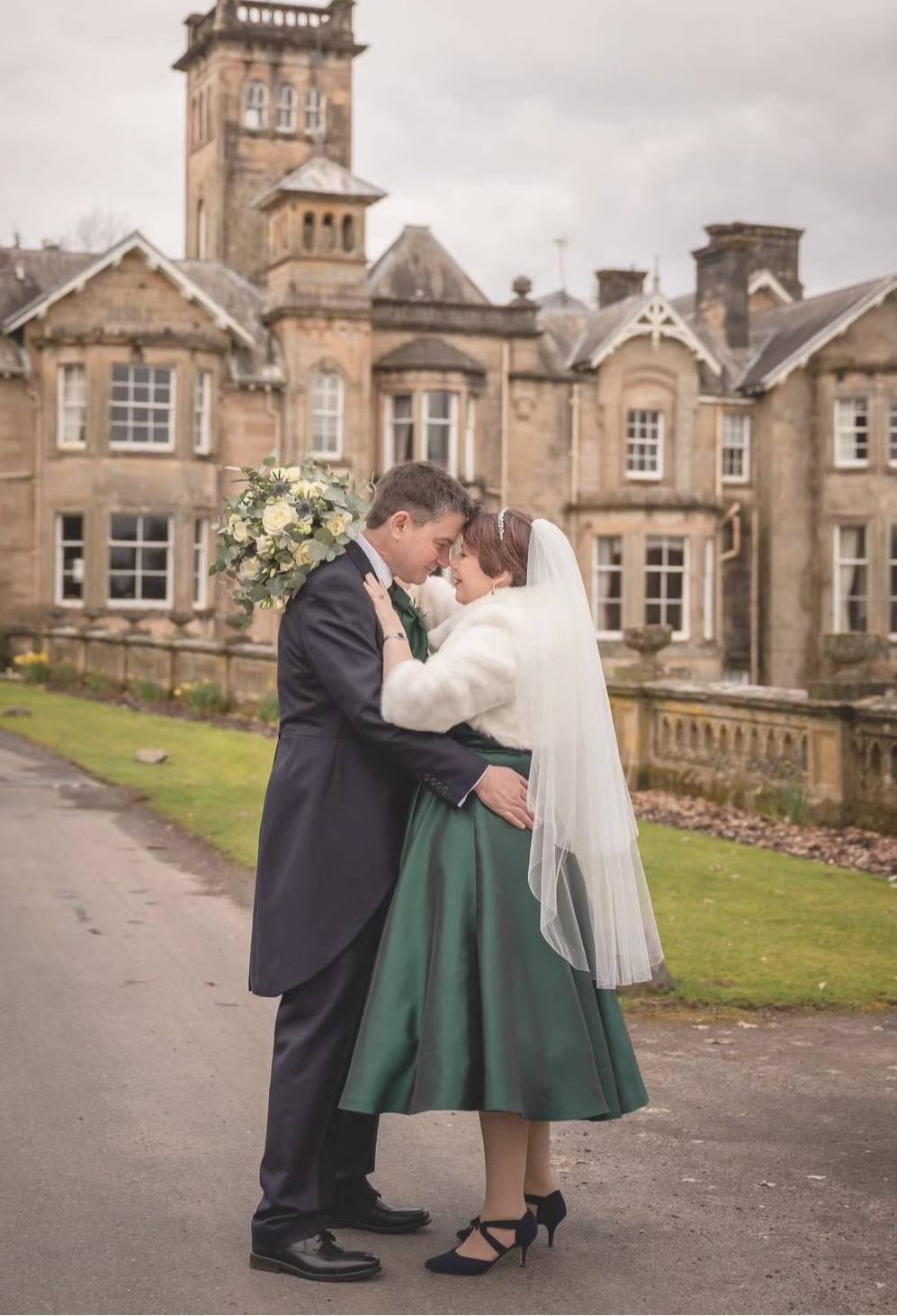 Photo of a bride and groom at a wedding, with the bride wearing Sargasso & Grey shoes